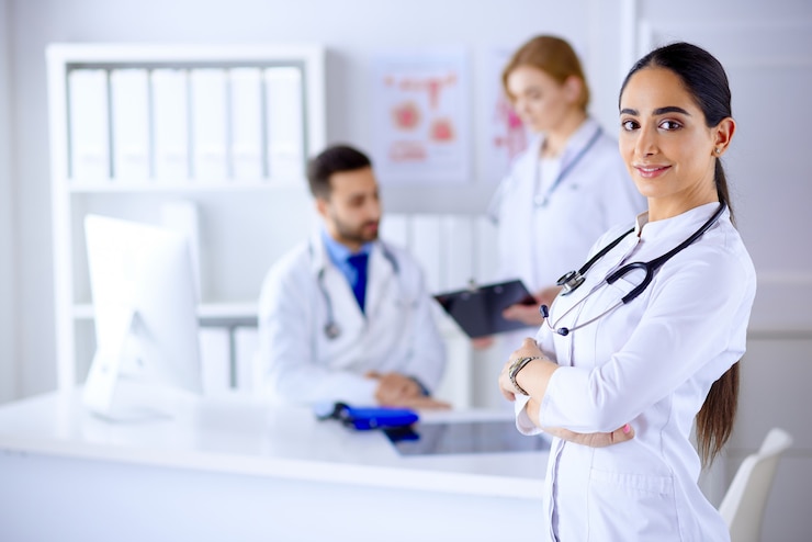 confident-female-doctor-front-team-looking-smiling-multiracial-team-with-arab-female-doctor_155404-7